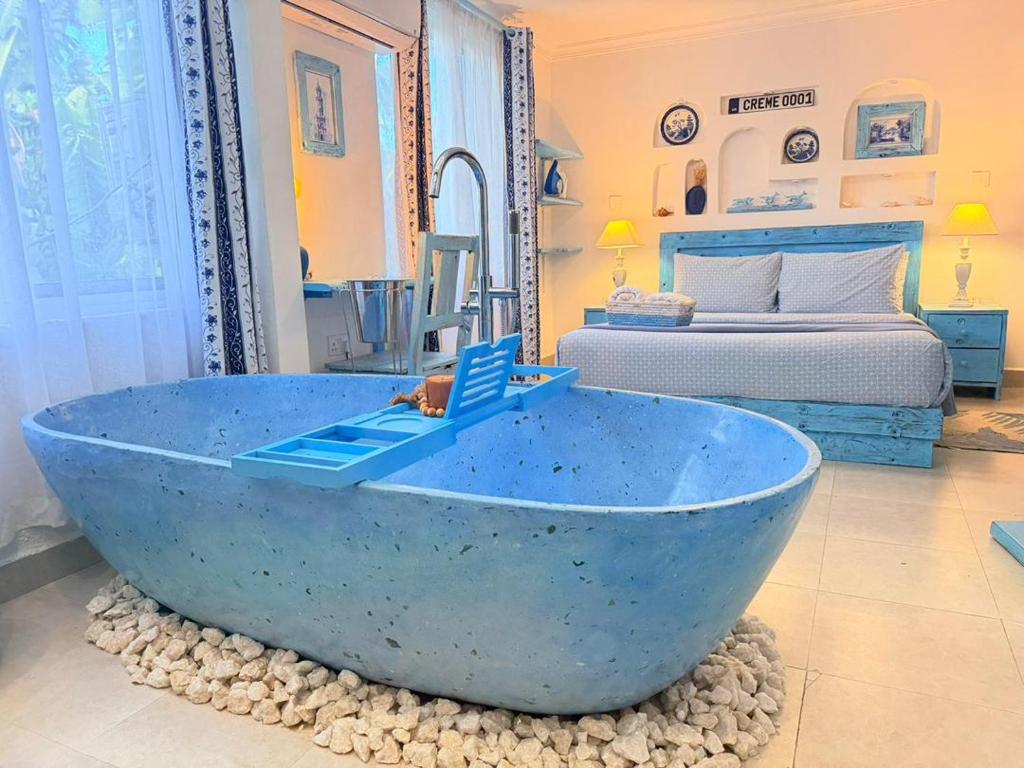 a blue bath tub in a room with a bed at 2 Bedroom en-suite studios by The Prime Escape in Arusha