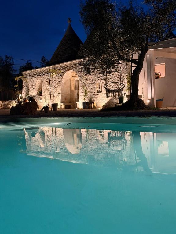 a large swimming pool in front of a building at Trulli Fichi Luxury Trullo with Private Spa and Saltwater Pool in Santa Lucia