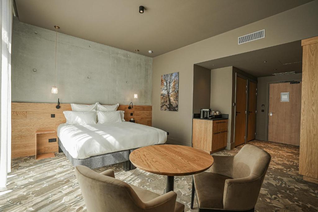 a hotel room with a bed and a table and chairs at La Chapelle in Annecy