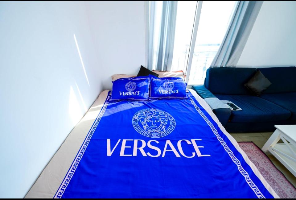a bed in a room with a blue blanket at Studio - Private - Abu Dhabi in Abu Dhabi