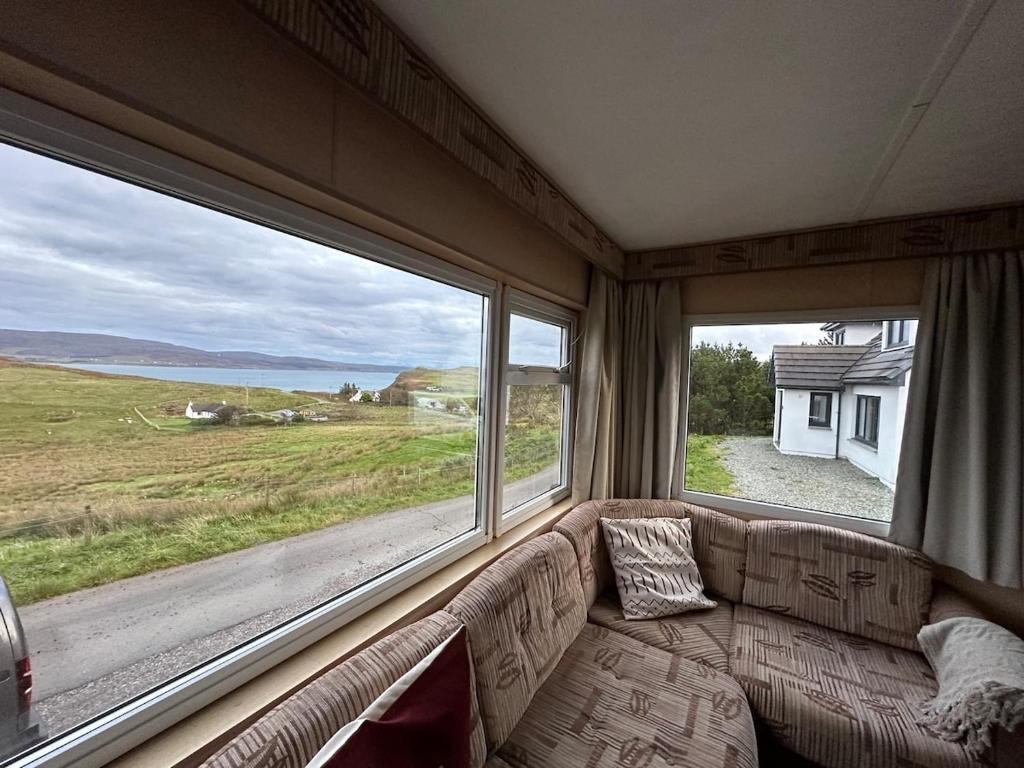a couch in a room with two large windows at Croft View Caravan Holidays in Dunvegan