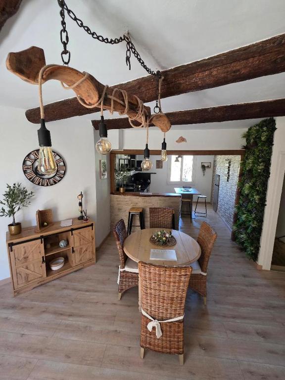a living room with a table and chairs at La Maison Delle Spellé - Meublé de Tourisme 4 étoiles in Piolenc