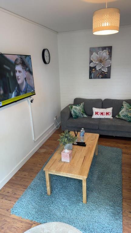 a living room with a couch and a coffee table at Two-bedroom house with a workspace in Basildon in Nevendon