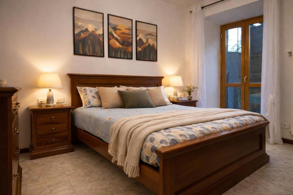 a bedroom with a bed with two night stands and two lamps at Casa Elisa in Onore