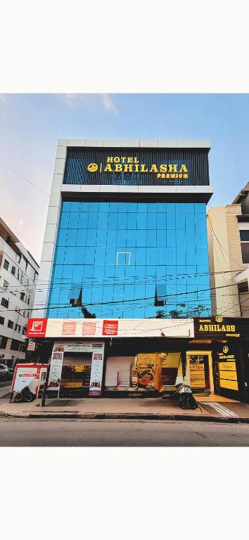 a large glass building with writing on it at Hotel Abhilasha Premium in Dewās