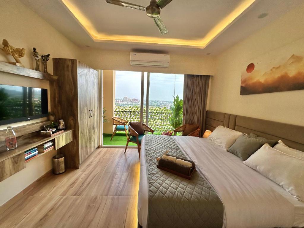 a bedroom with a large bed and a large window at The Rudraya - Suites in Greater Noida