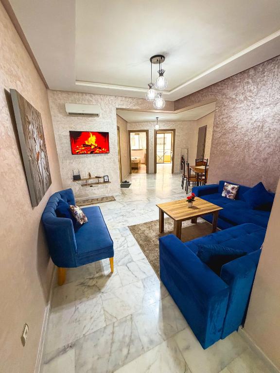 a living room with blue couches and a table at Vivienda 01 Appartement moderne au cœur de Mohammedia , Calme et Confort in Mohammedia