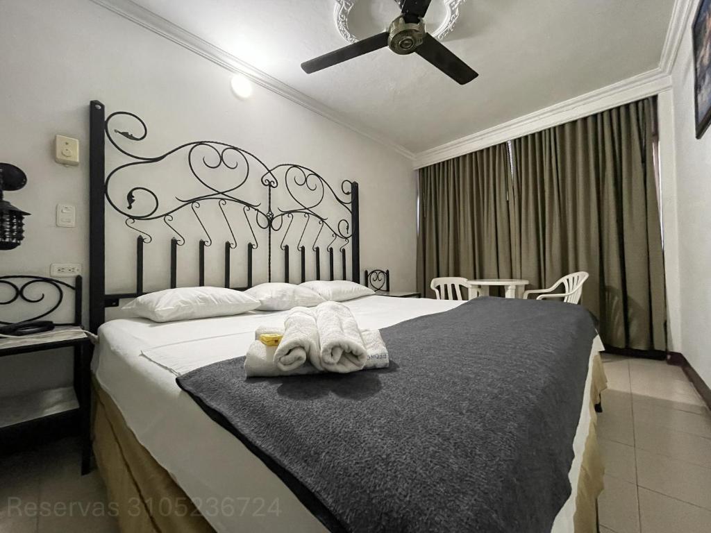 a bedroom with a bed with a towel on it at Hotel Terraza Girardot in Girardot