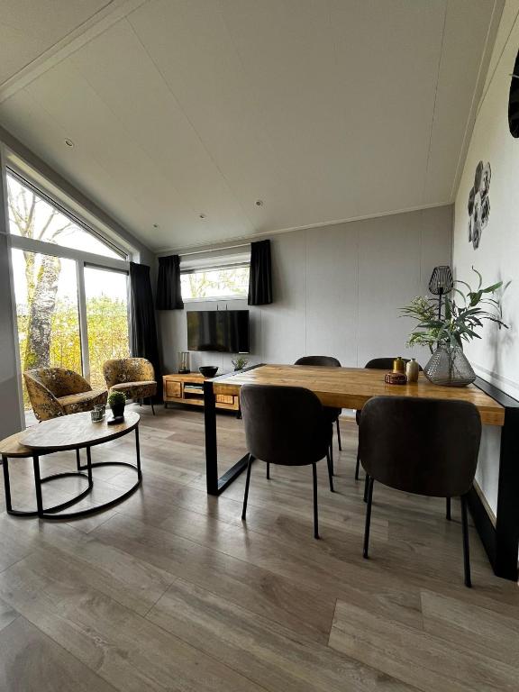 a living room with a large wooden table and chairs at Veluwe Retreat Inn Otterlo! in Otterlo