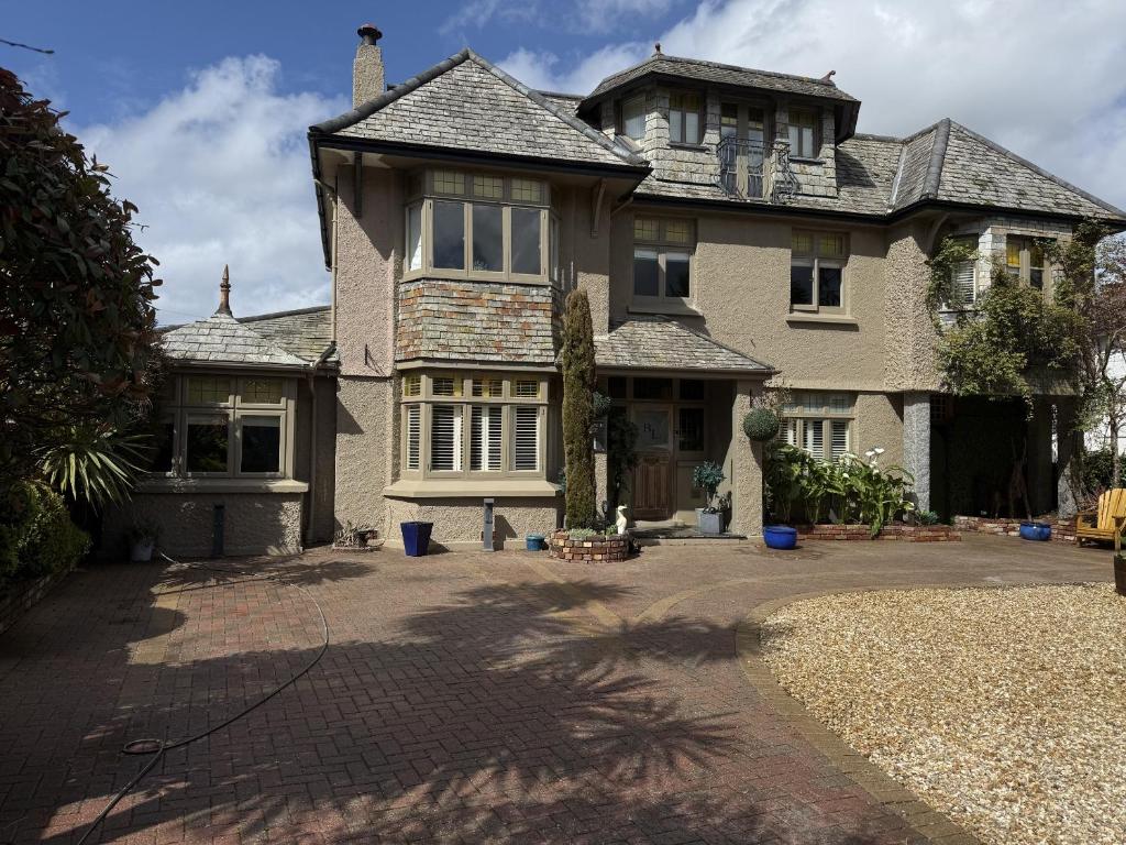 a large house with a driveway in front of it at Bradleigh Lodge in St Austell