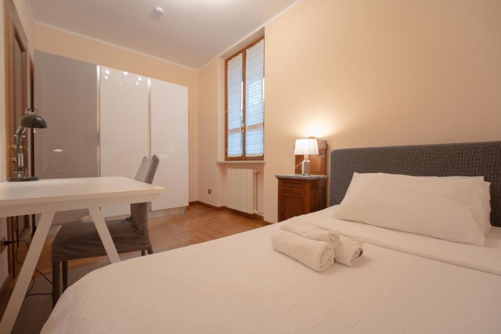 a bedroom with a bed and a desk and a window at Appartamento indipendente in villa a Casalpusterlengo in Casalpusterlengo