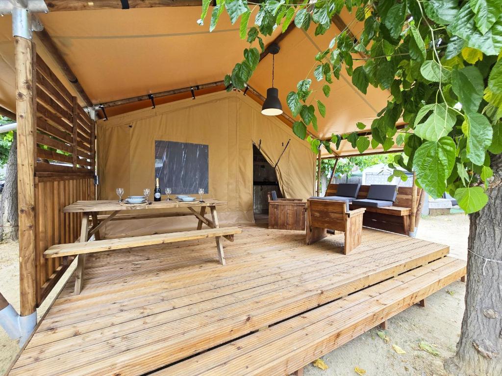 a tent with a table and benches in it at Camping Costa Dorada Tienda Lua in Canet de Mar