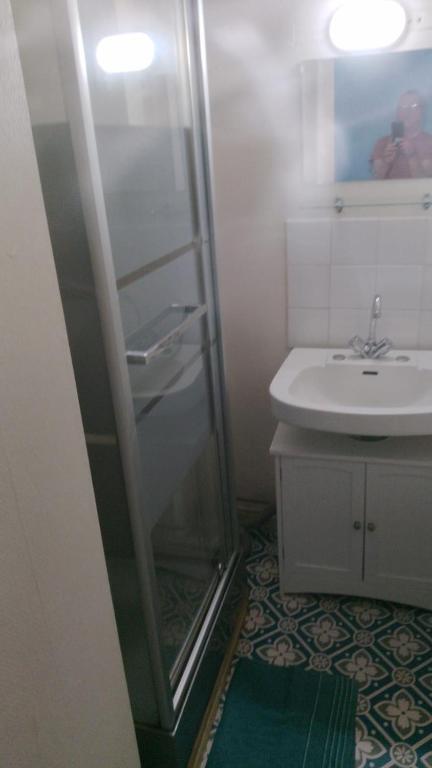 a bathroom with a glass shower next to a sink at Relais de Bénévent in Bénévent-lʼAbbaye