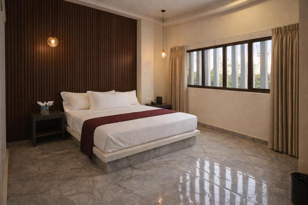 a bedroom with a bed and a large window at Hotel Olimpica Boutique in Mexico City