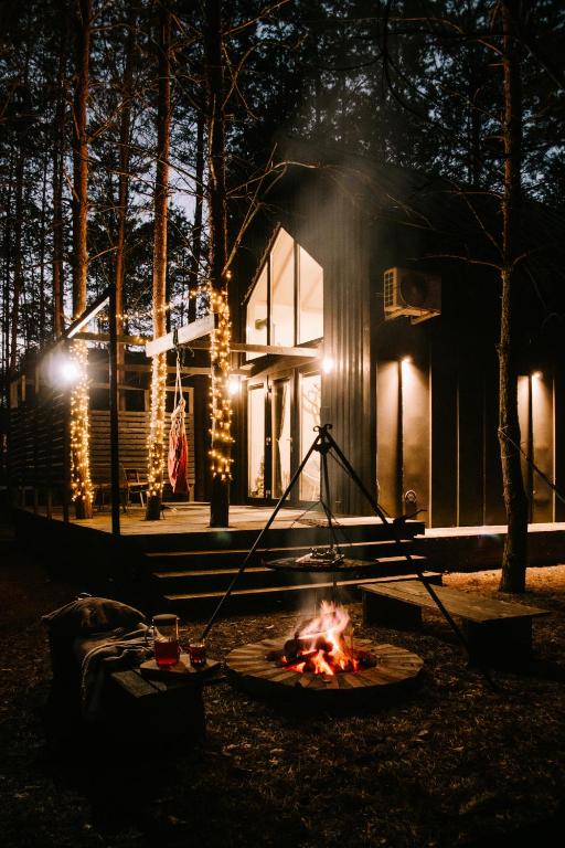 a fire pit in front of a house at night at Domek SzumiSosna2 in Życiny