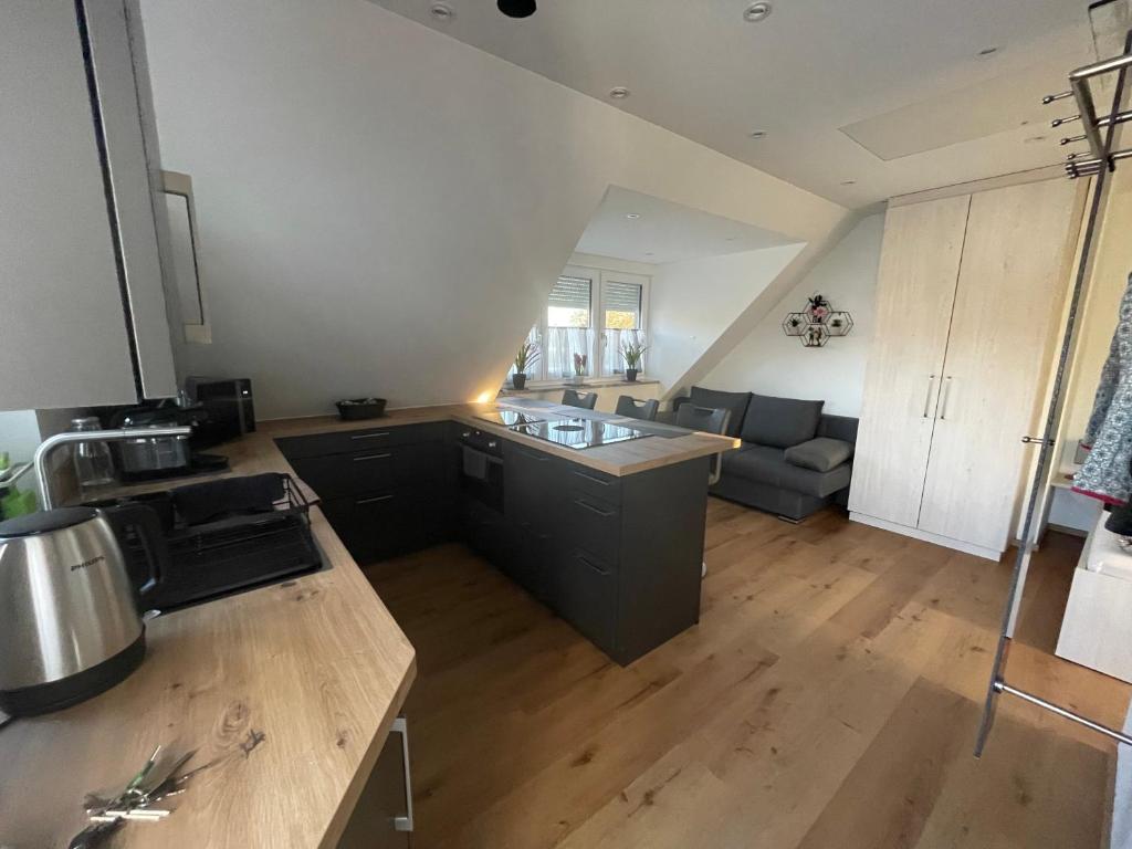 an open kitchen and living room with a couch at Apartments Reischl in Bergkirchen