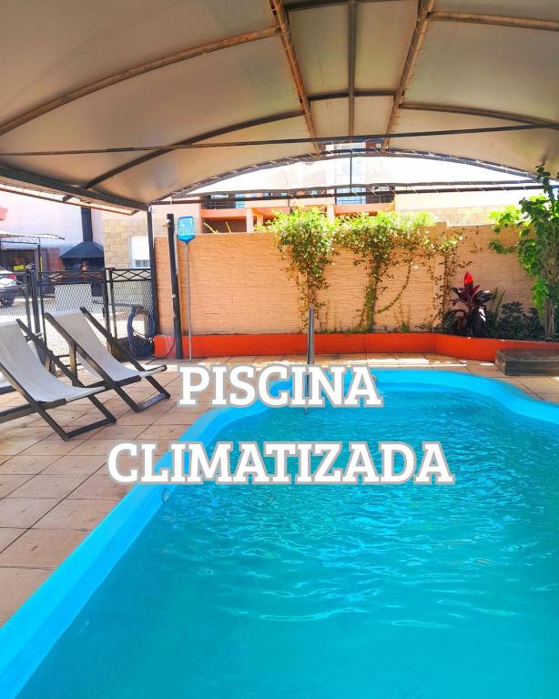 a blue swimming pool with a canopy and chairs at Renacer in Federación