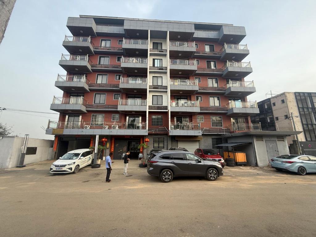 a large apartment building with cars parked in a parking lot at 海客瀛洲 Haïke-Îlezone in Abidjan