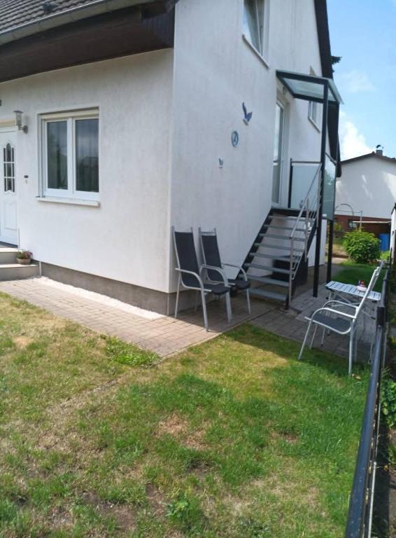 two chairs sitting on a porch with a house at Zum Graureiher in Heringsdorf