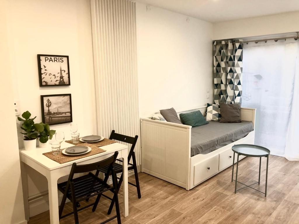 a small bedroom with a bed and a table and chairs at Le Petit Ekrin des Ursines in Vélizy-Villacoublay