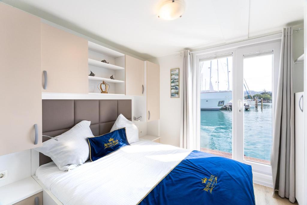 a bedroom with a bed with a view of the water at Floating House Royal Blue Portorož in Portorož