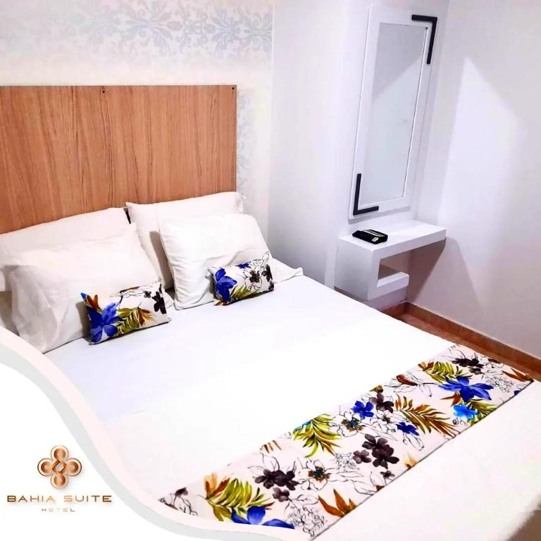 a bedroom with a white bed with a mirror at Bahia Suite Alojamiento Centro historico in Santa Marta