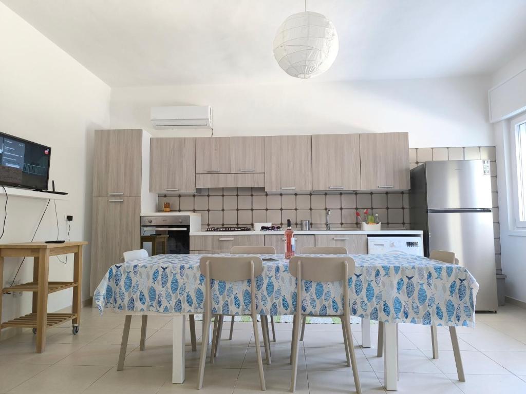 a kitchen with a table with chairs and a refrigerator at Casa Solento in Campomarino