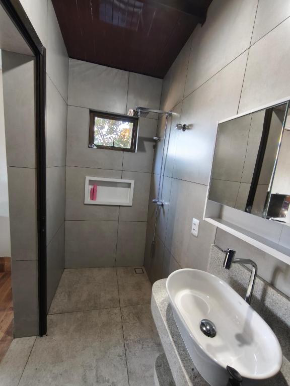 a bathroom with a sink and a mirror at Quatro com suite e cozinha in Brumadinho