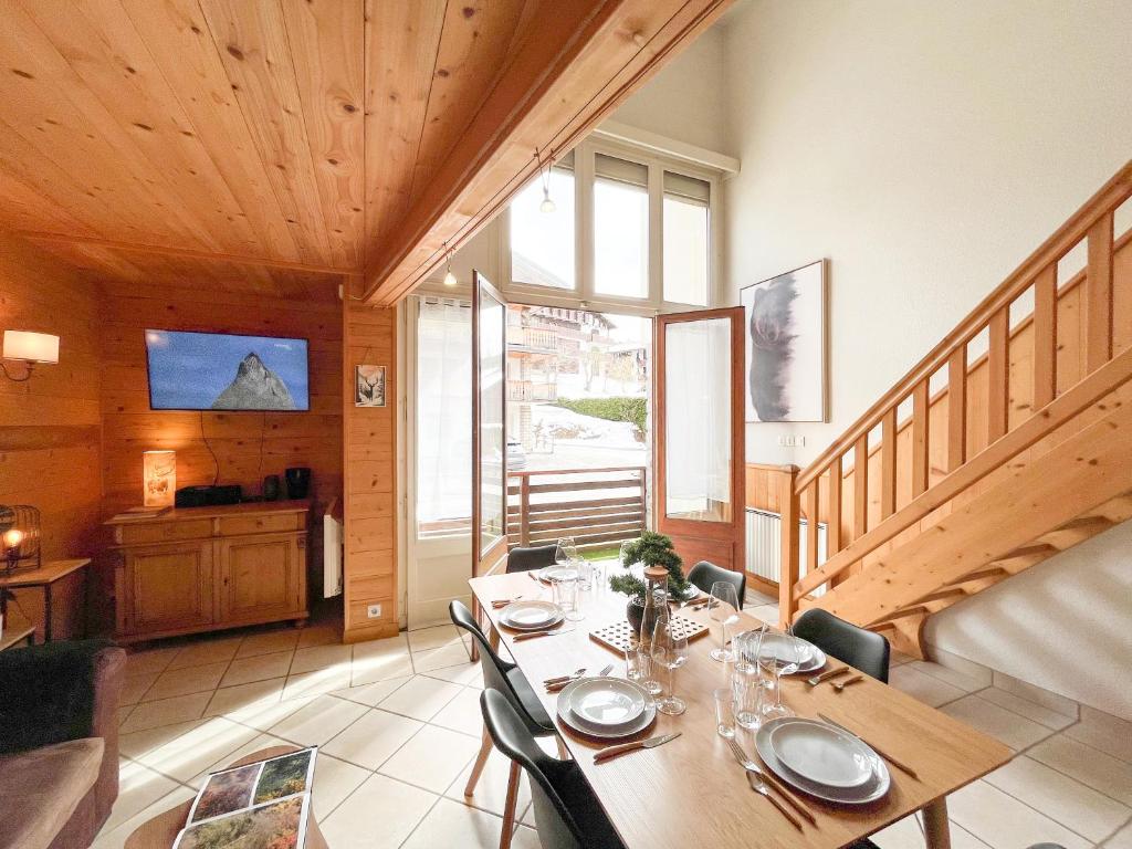 a dining room with a table and a staircase at Duplex Les Gets Centre Local VTT Sécurisé & Balcon 6P in Les Gets