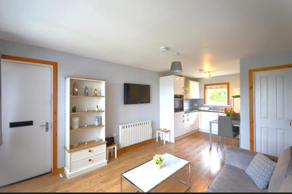 a living room with a couch and a kitchen at Cozy 1 bed flat in Stornoway in Stornoway
