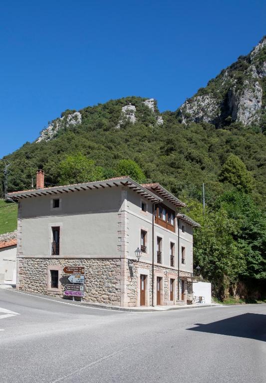 a building on the side of a road with a mountain at Hotel Boutique Las dos Peñas in Mier