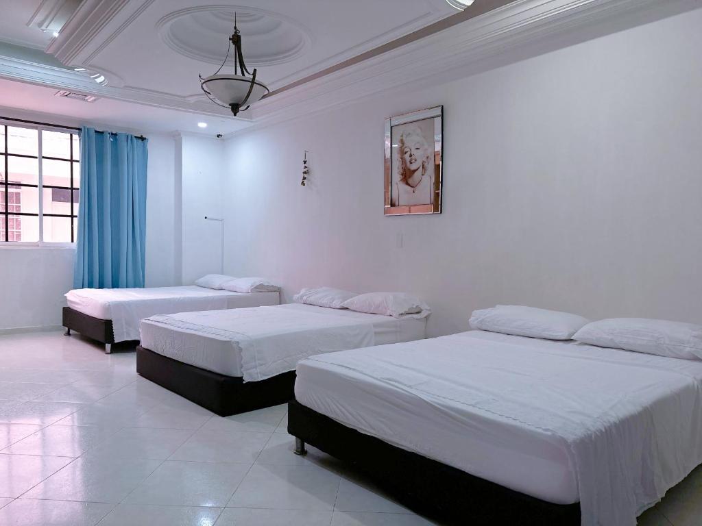 two beds in a room with white walls at Habitaciones Casa Lisboa in San Andrés