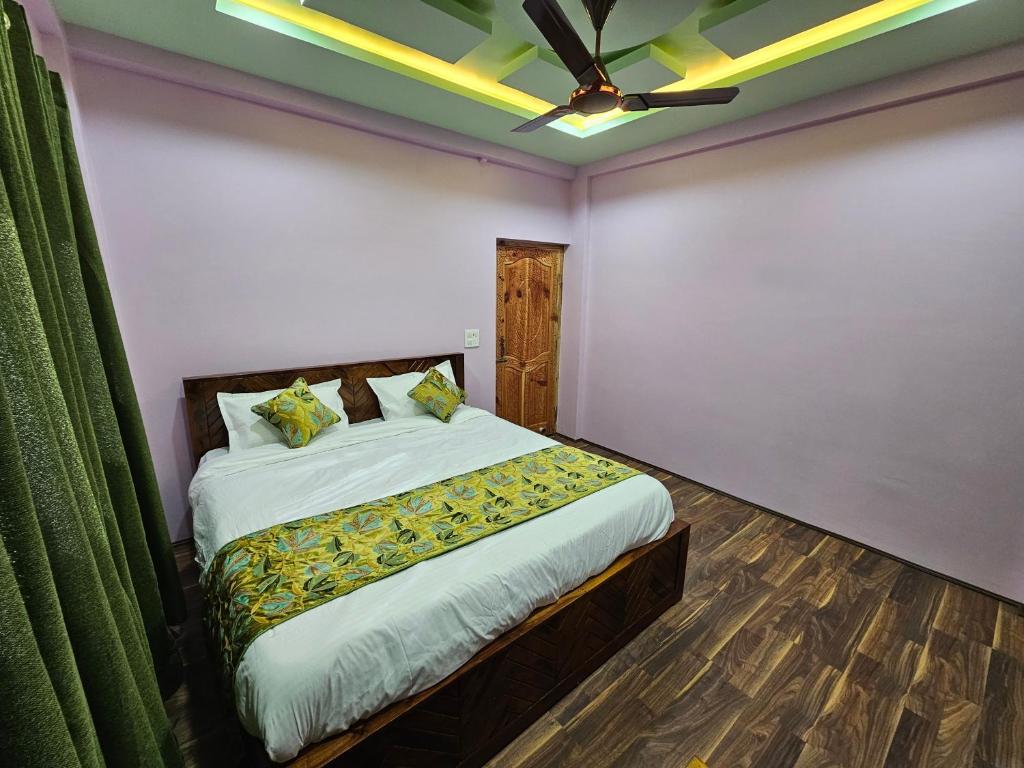 a bedroom with a bed and a ceiling fan at Hotel Riverwood Kokernag in Wāngom