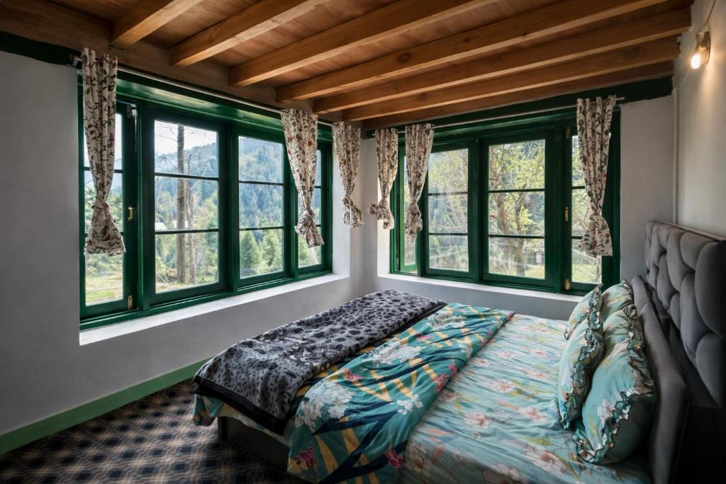 a bedroom with a bed in a room with windows at Jungle Bungalow in Pahalgām