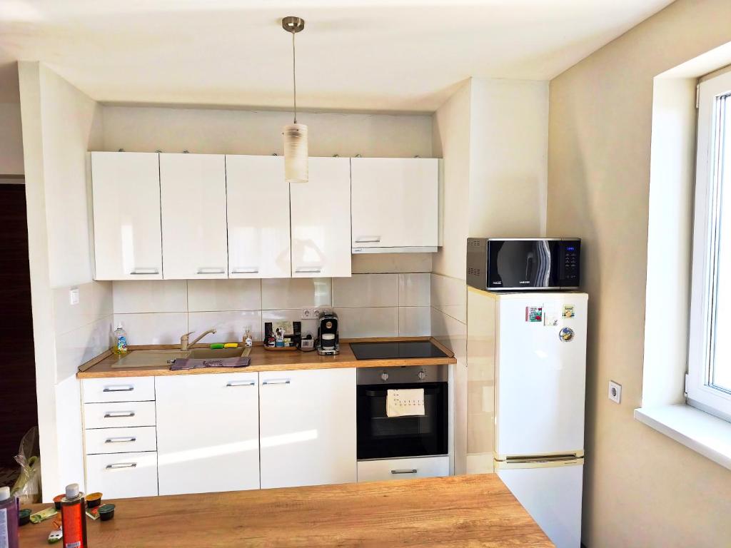 a kitchen with white cabinets and a white refrigerator at Nagyerdő - Simonyi út in Debrecen