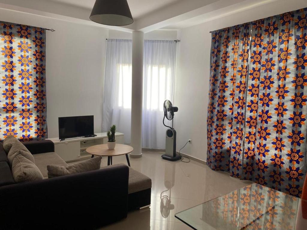 a living room with a couch and a tv at sempri djuntu T1A in Tarrafal