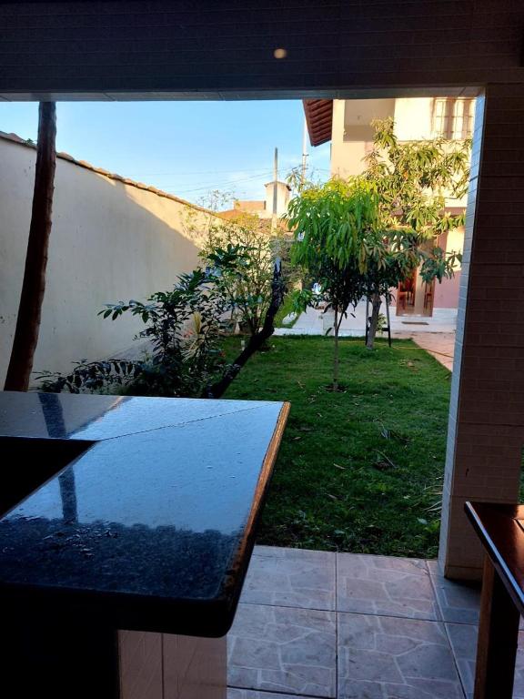 a view of a garden with a table in a room at Brilho do Sol in Guarapari
