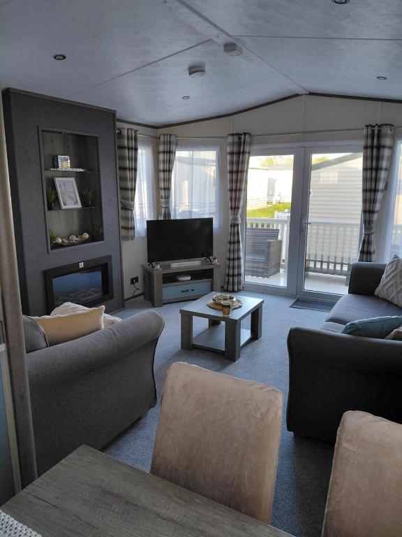 a living room with couches and a television at Hoburne Devon Bay - 2 Bed Caravan - Activity Passes Included in Goodrington