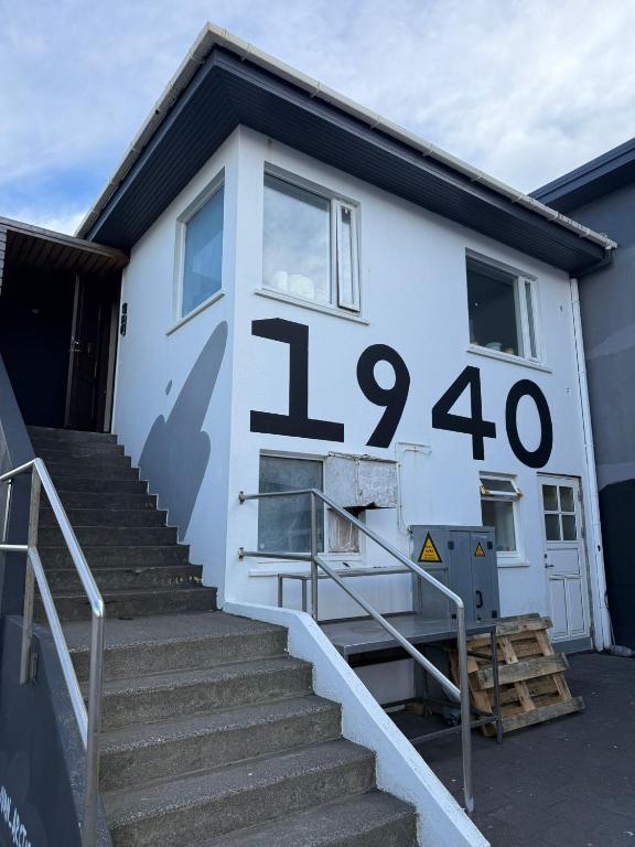 a white house with a clock on the side of it at Whale House in Keflavík