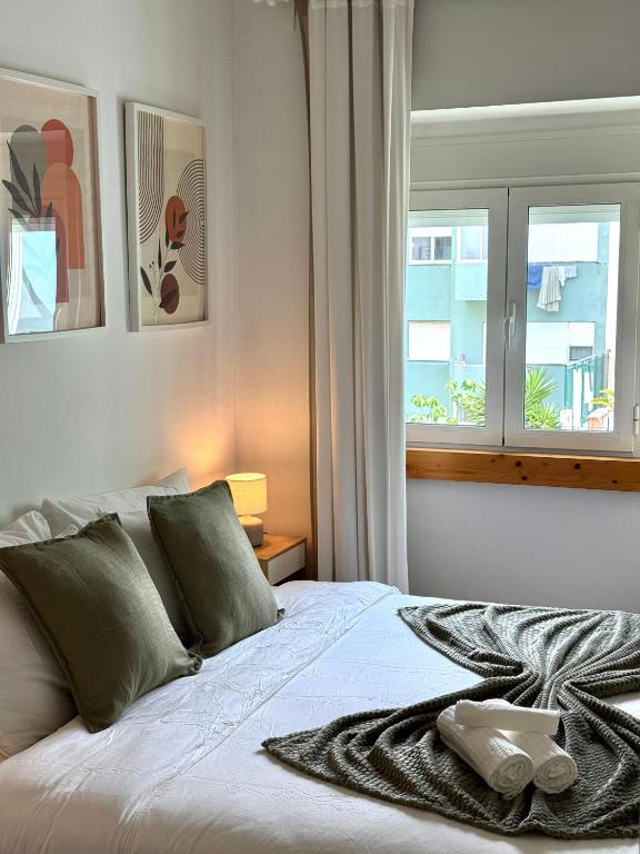 a bedroom with a white bed with a window at Aura Campo de Ourique - Near the Tram 28 stop in Lisbon