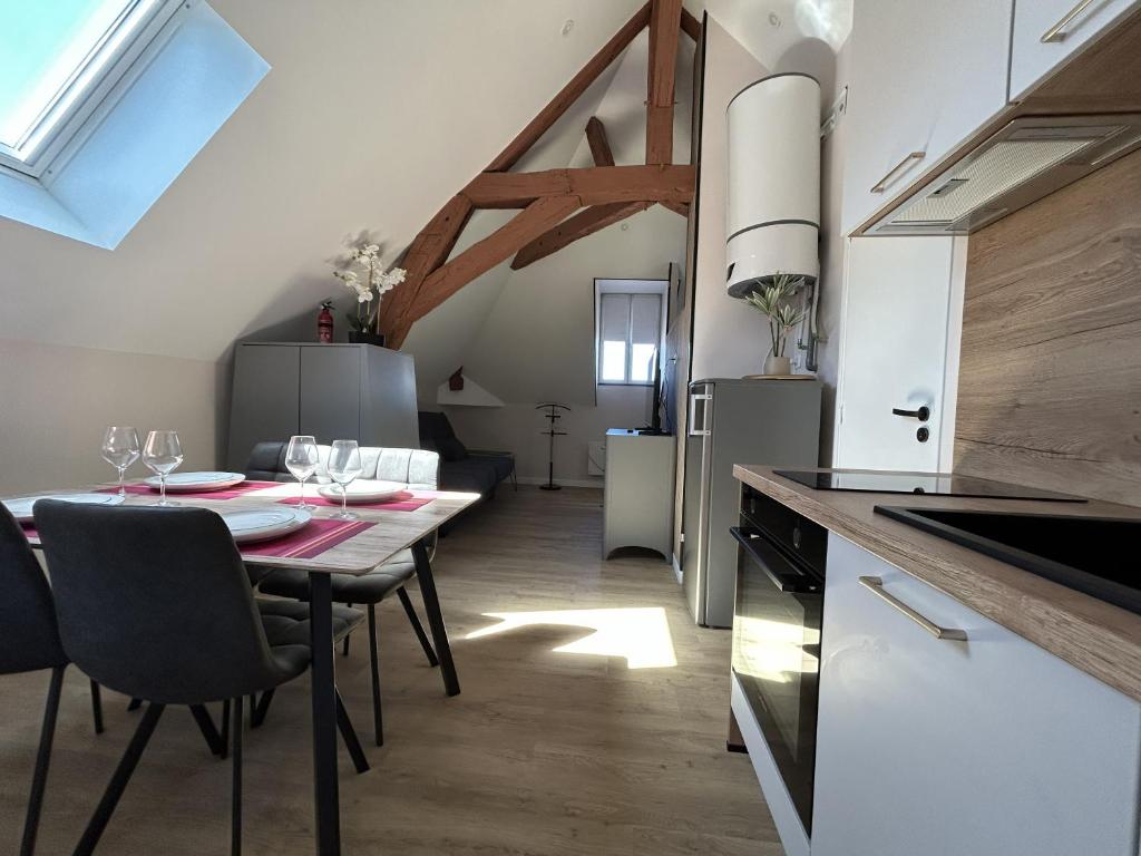 a kitchen and dining room with a table and chairs at Logement climatisé avec cuisine équipée in Amboise