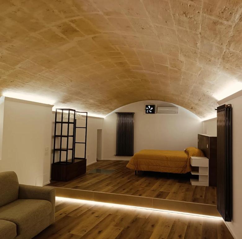 a bedroom with a bed and a couch in a room at Alma Mater Suite in Matera