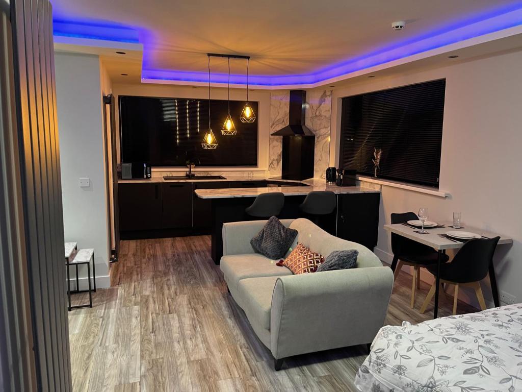 a living room with a couch and a kitchen at Modern Junior Suite, Seascale, Cumbria in Seascale