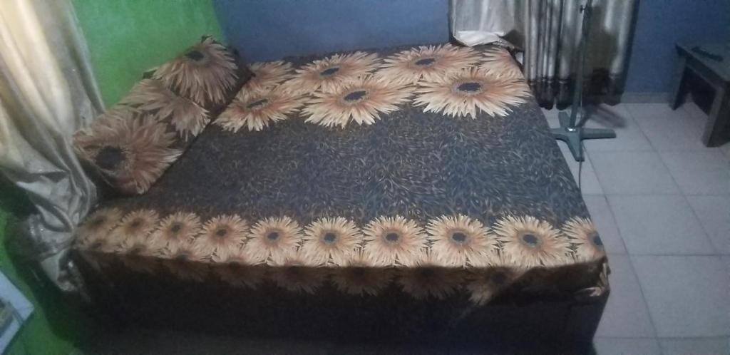 a couch with flowers on it in a room at JK Hotels in Lagos
