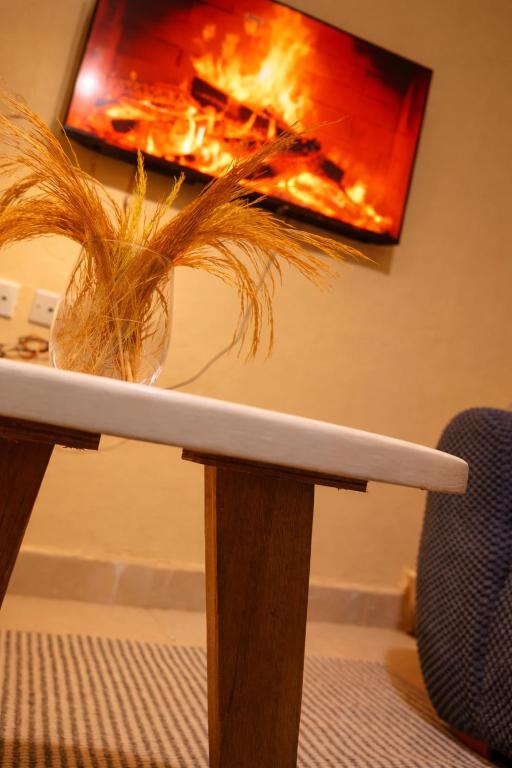 a table with a vase of grass on top of it at H&Dluxe in Murangʼa