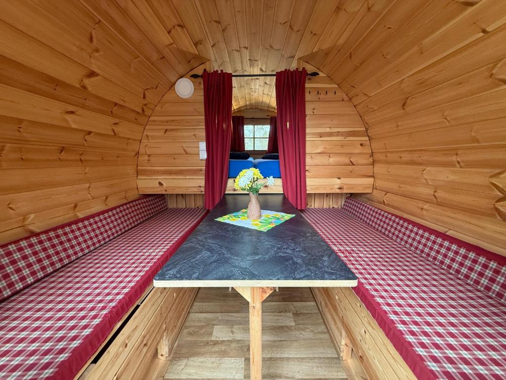 a room in a wooden cabin with a table in it at Campingfass Zur Adria in Großdubrau