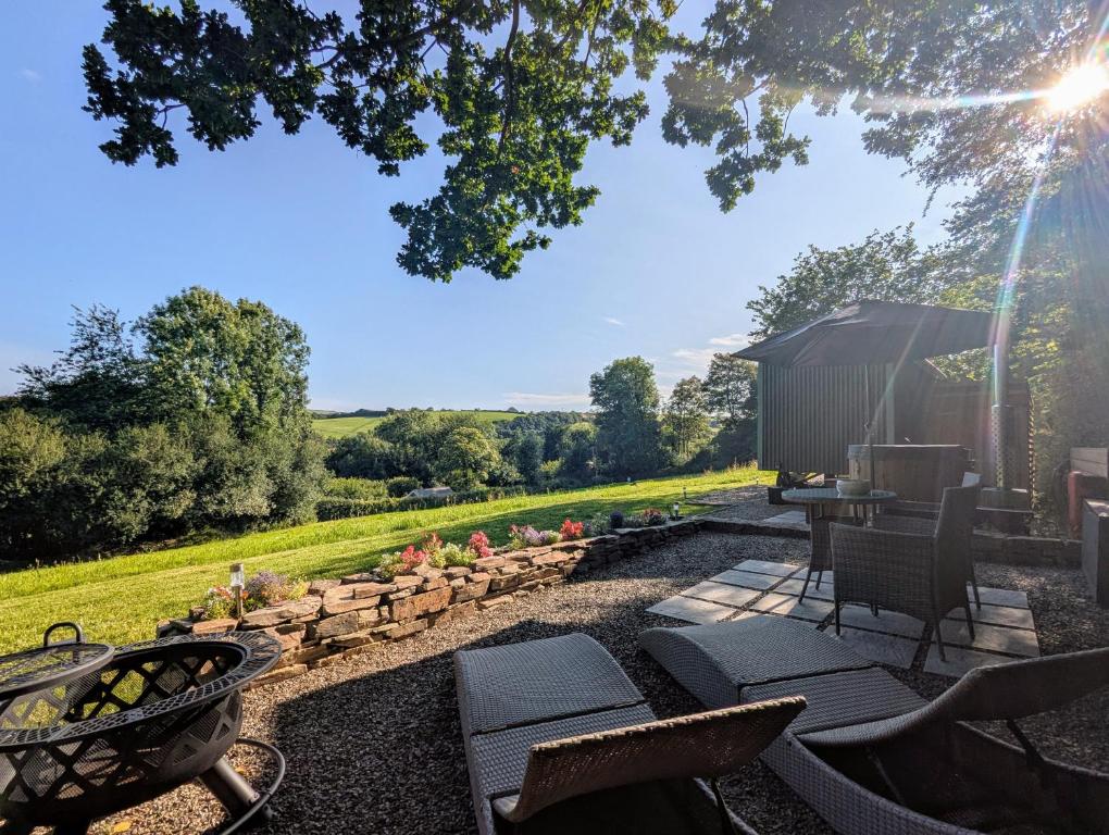 a backyard with a fire pit and chairs and a grill at Cornish Valley Retreat in Bodmin