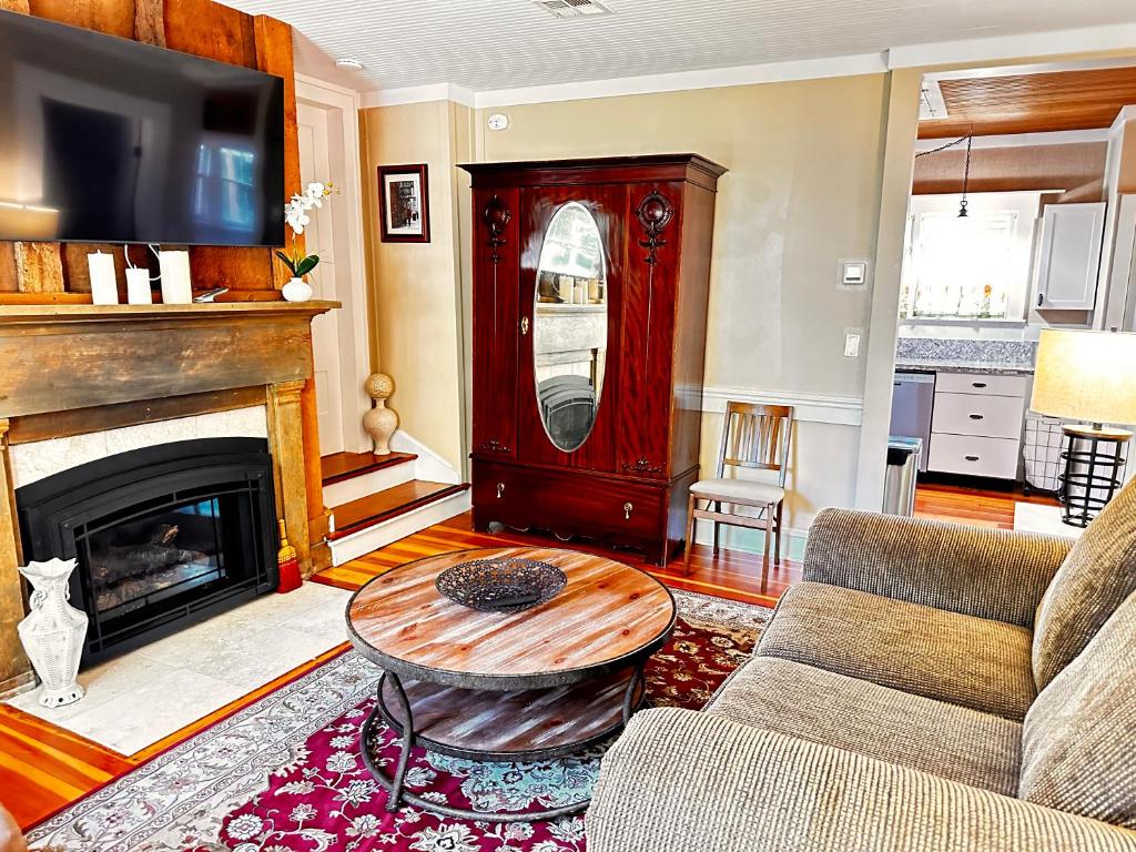 a living room with a couch and a table and a fireplace at Fireside Cottage in Jacksonville