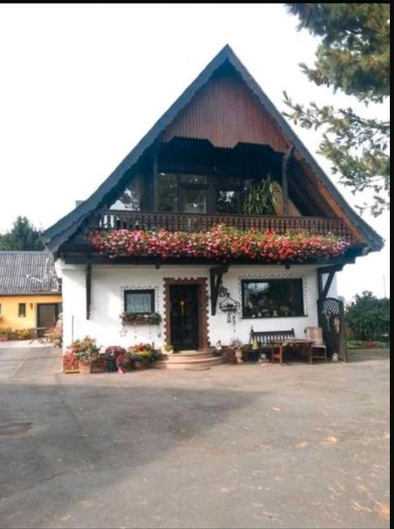 a house with a balcony with flowers on it at Eselhof Oberlascheid in Oberlascheid