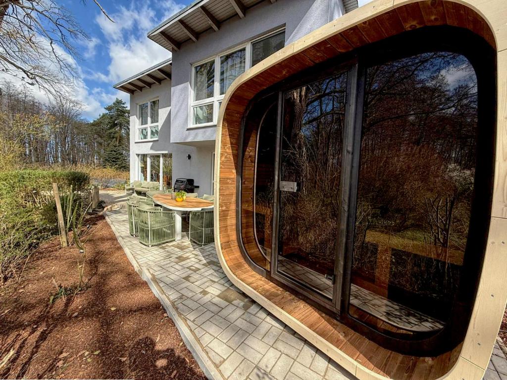 a large window on the side of a house at Ferienhaus TRAUM AM SEE mit Sauna und Whirlpool in Zislow